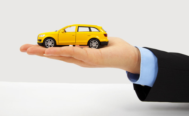 Businessman’s hand holding a car